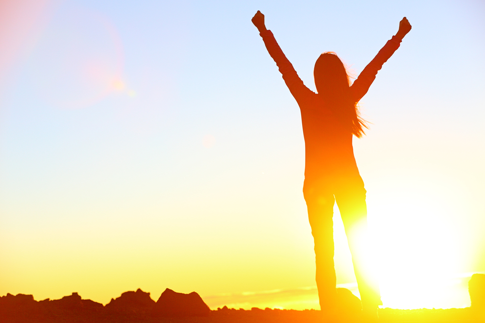 Woman Letting Go Raised Arms in Sunset